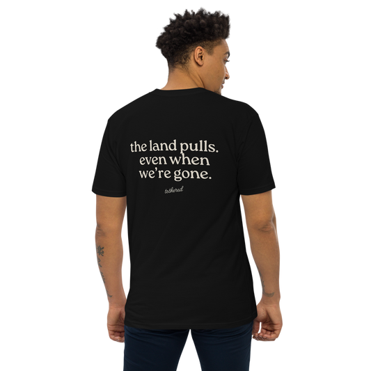 model wearing black the land pulls tee standing outdoors