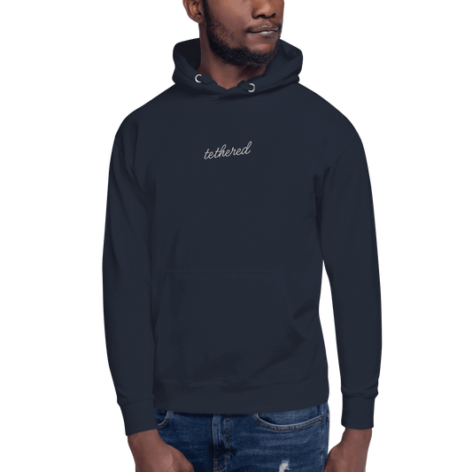 model wearing navy blue tethered hoodie outdoors